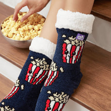 Load image into Gallery viewer, The Foozie™ Popcorn slipper socks, close-up worn on a wooden stair with a hand in a bowl of popcorn