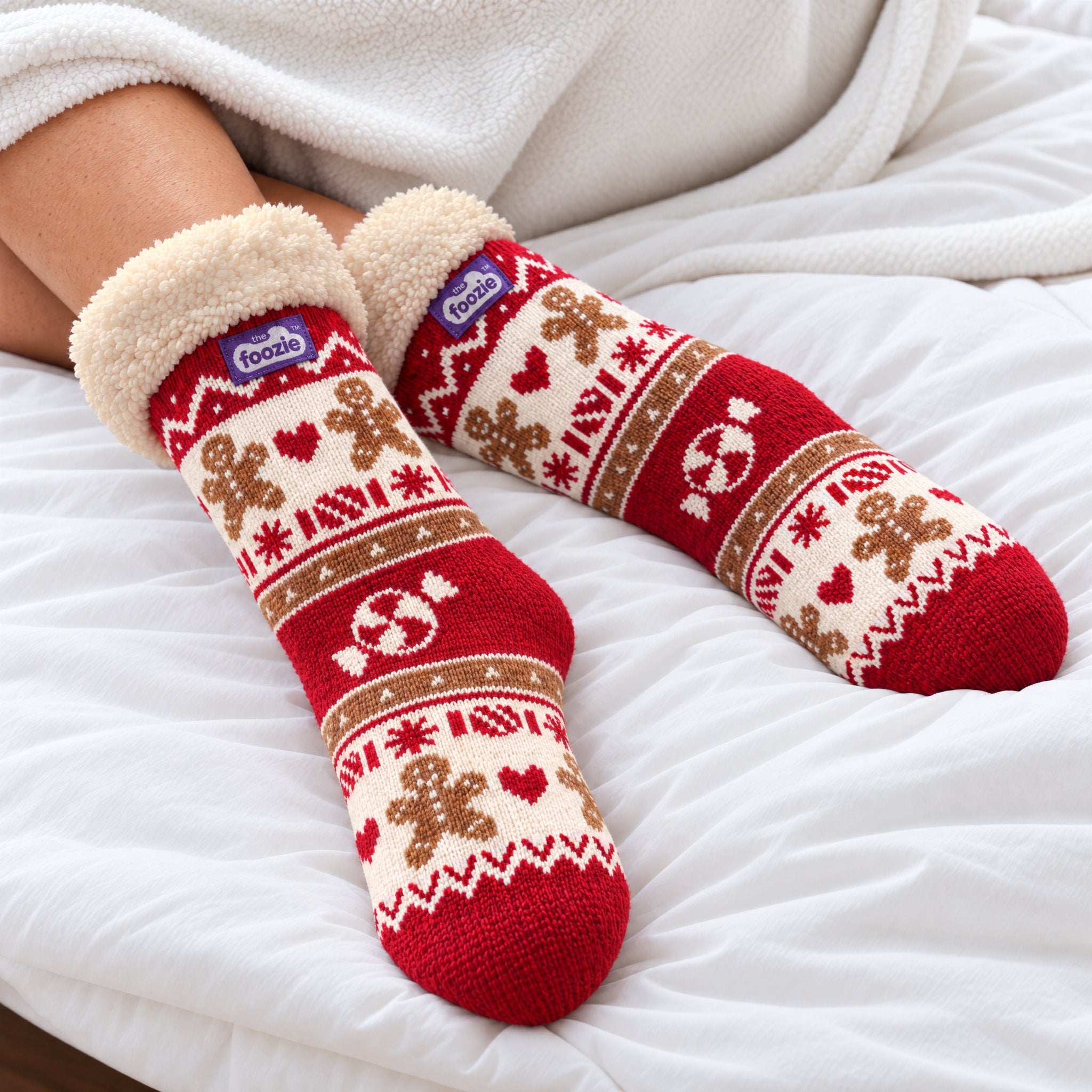 The Foozie™ Christmas Gingerbread slipper socks, on a cosy duvet