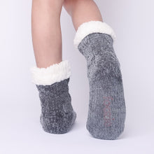 Load image into Gallery viewer, The Foozie™ in Dark Gray, back view worn in Kids/Small with one foot raised to show the non-slip grips on the sole
